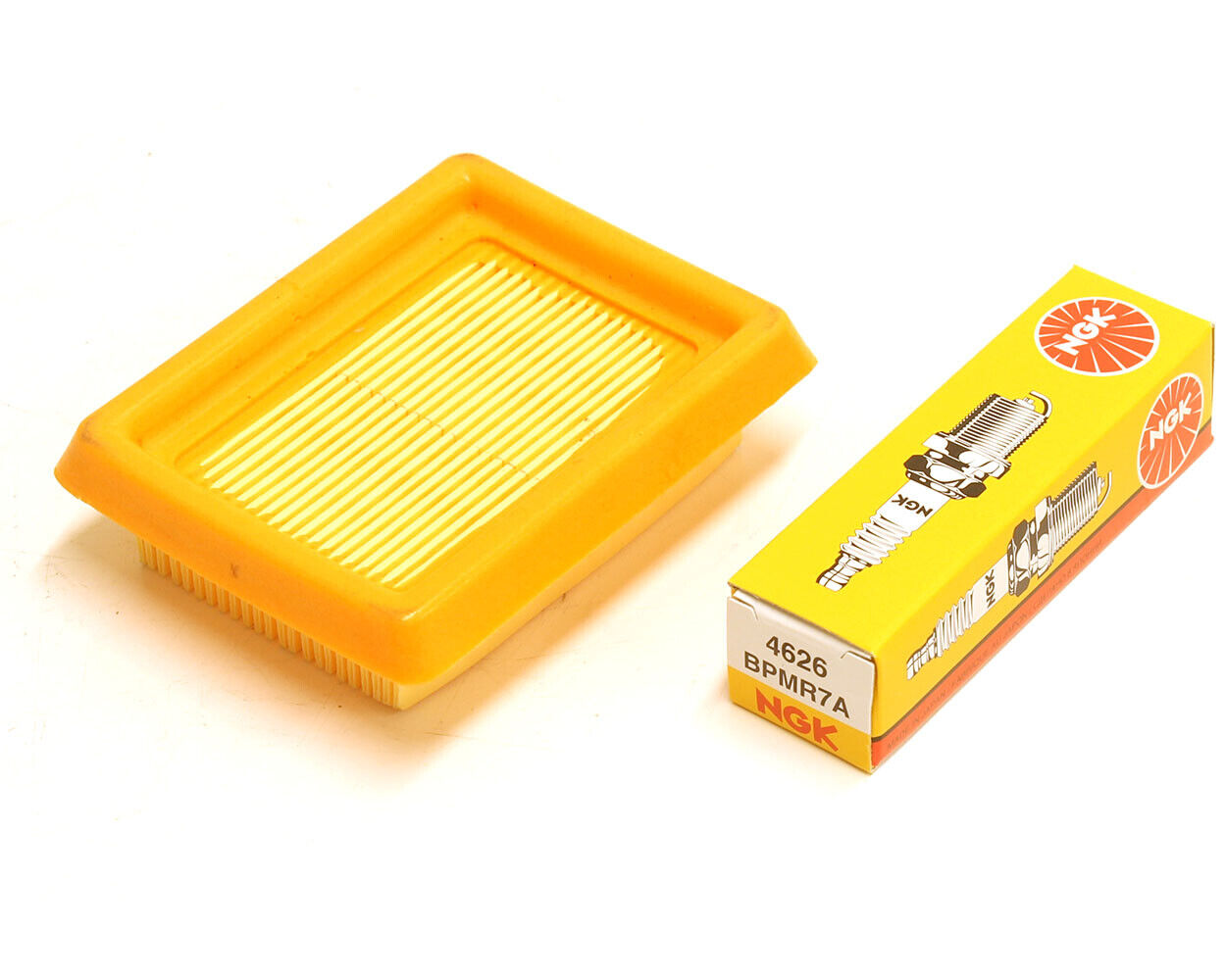 Orange Stihl air filter to suit brushcutter models FS120,FS200,FS250,FS300,FS350,FS400,FS450 with an NGK BPMR7A spark plug laying beside it